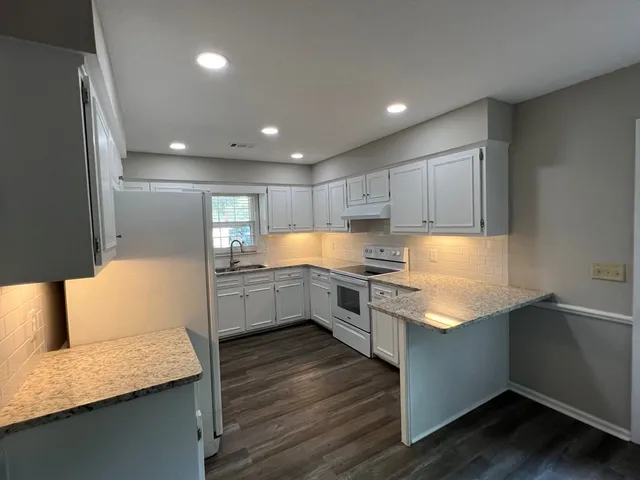 a kitchen with white cabinets and white appliances