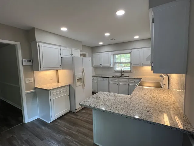 a kitchen with stainless steel appliances granite countertop a sink and a refrigerator