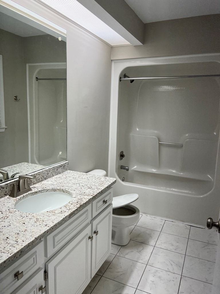 4456 Ritch Haven Road Columbus, GA 31909 - Photo 10 of 14 a bathroom with a granite countertop sink a toilet and bathtub