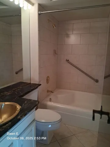 a bathroom with a granite countertop toilet and a bathtub