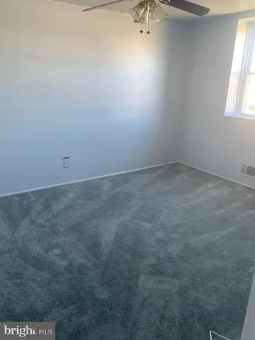 a kitchen with a refrigerator and white cabinets