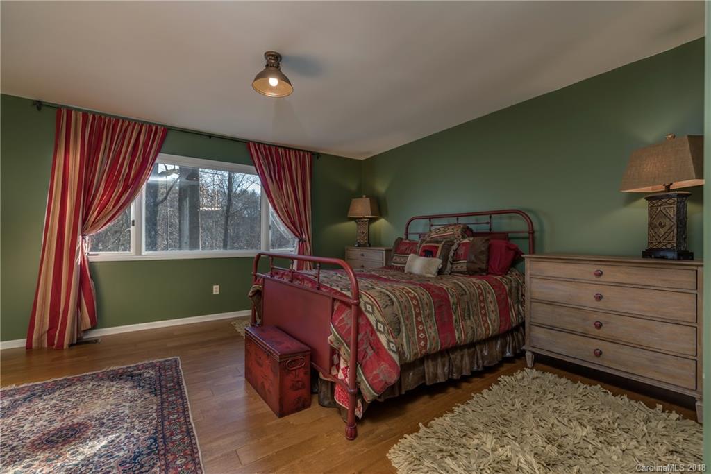 29 Hunting Country Trail Tryon, NC 28782 - Photo 12 of 20 a bedroom with a bed and a dresser next to a window