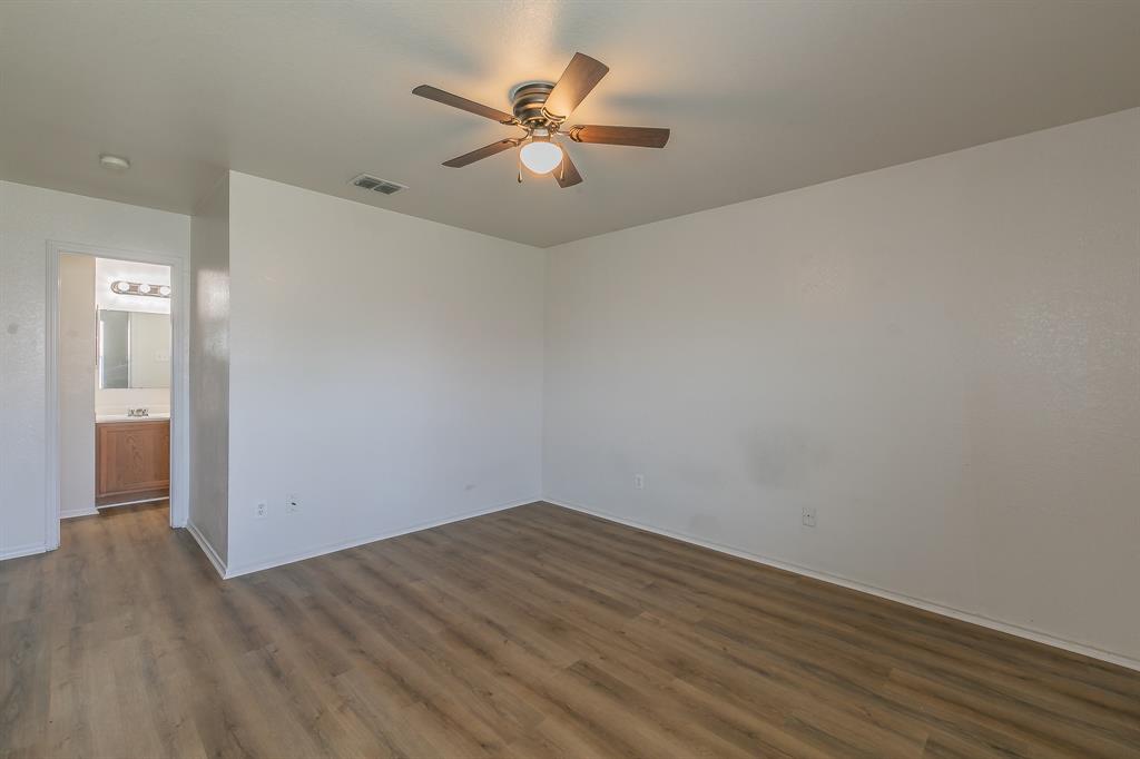 213 Cres Ridge Drive Fort Worth, TX 76140 - Photo 16 of 32 an empty room with wooden floor and fan