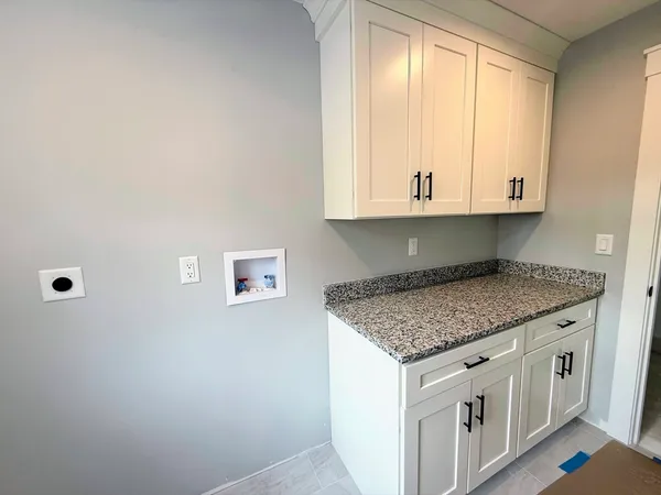 a kitchen with white cabinets and a window