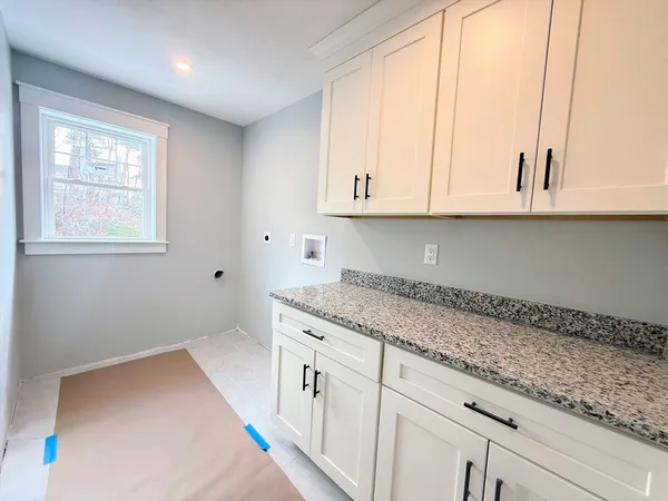 a kitchen with granite countertop white cabinets and a window