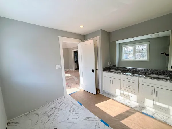 a spacious bathroom with a granite countertop sink and a mirror
