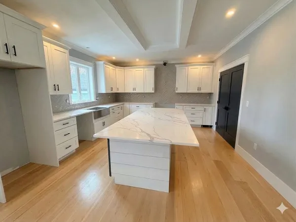 a kitchen that has a lot of cabinets in it and wooden floor