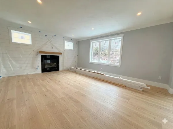 an empty room with fireplace and windows