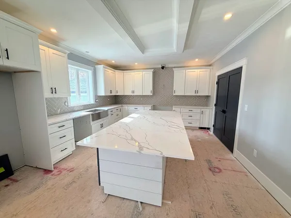 a large white kitchen with cabinets