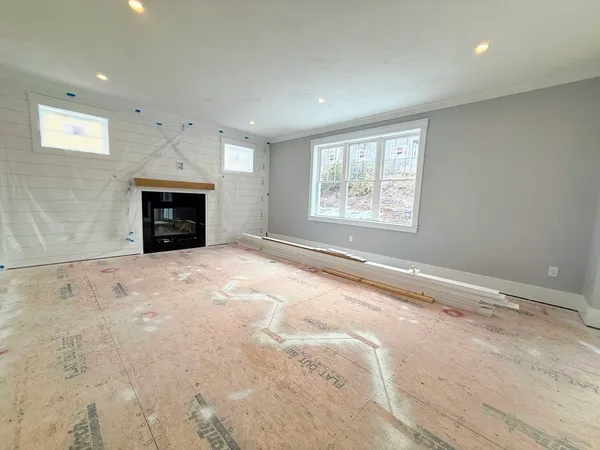 a view of an empty room with a fireplace and a window
