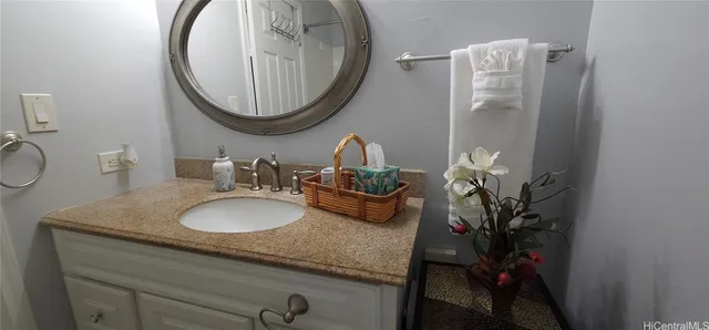 a bathroom with a granite countertop sink and a mirror