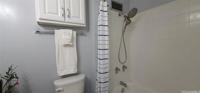 a bathroom with a granite countertop shower and a toilet