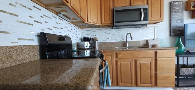 a kitchen with stainless steel appliances granite countertop a stove microwave sink and refrigerator