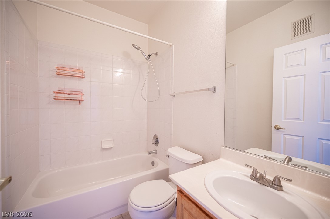 8555 West Russell Road, Unit 2062 Las Vegas, NV 89113 - Photo 31 of 35 A well-lit bathroom, featuring a clean white vanity and classic shower-tub combination.