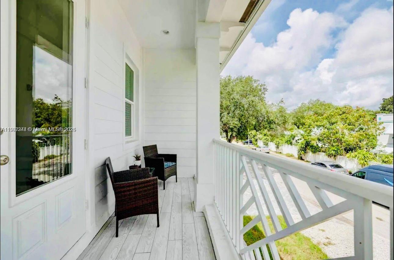667 Southwest Cleveland Avenue, Unit 3 Stuart, FL 34994 - Photo 11 of 42 a balcony view with couple of chairs and wooden floor