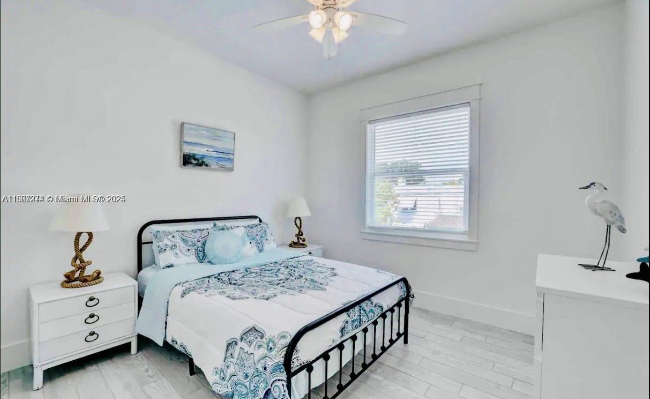 667 Southwest Cleveland Avenue, Unit 3 Stuart, FL 34994 - Photo 19 of 42 a bedroom with a bed and a chandelier