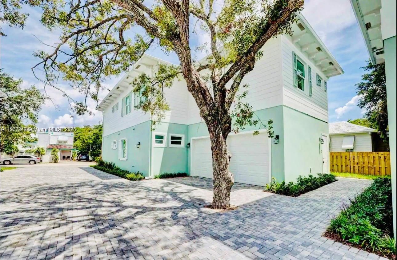667 Southwest Cleveland Avenue, Unit 3 Stuart, FL 34994 - Photo 2 of 42 a front view of a house with a garden