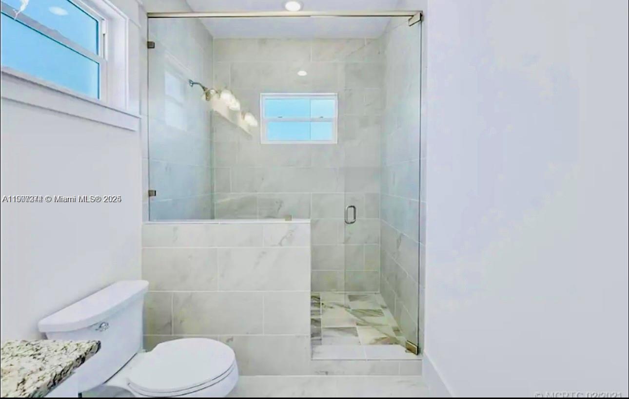 667 Southwest Cleveland Avenue, Unit 3 Stuart, FL 34994 - Photo 28 of 42 a bathroom with a toilet and a shower