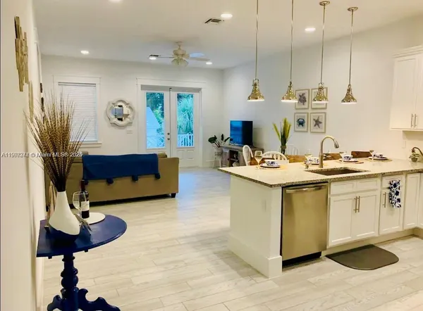 a living room with stainless steel appliances kitchen island granite countertop furniture and a view of kitchen