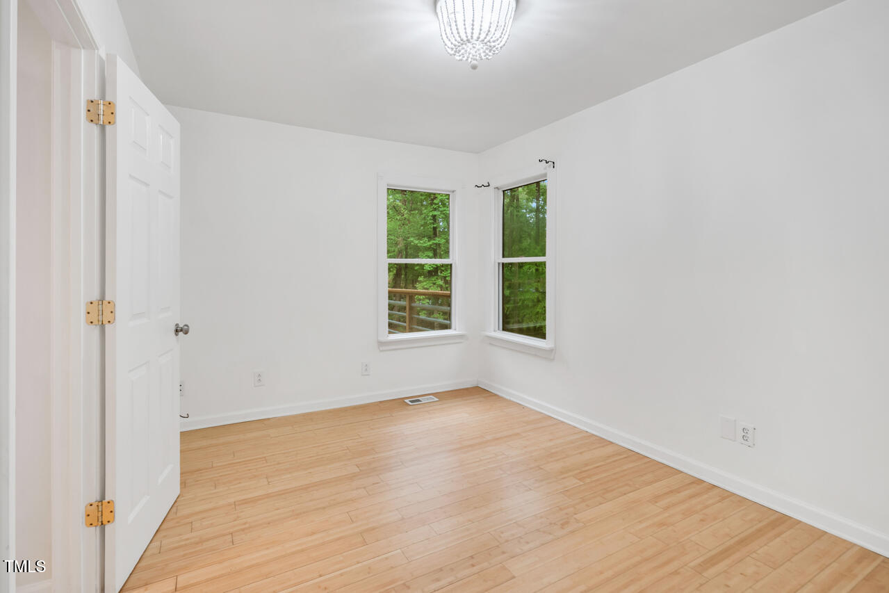 121 Lady Bug Lane Chapel Hill, NC 27516 - Photo 15 of 36 a view of an empty room with wooden floor and a window