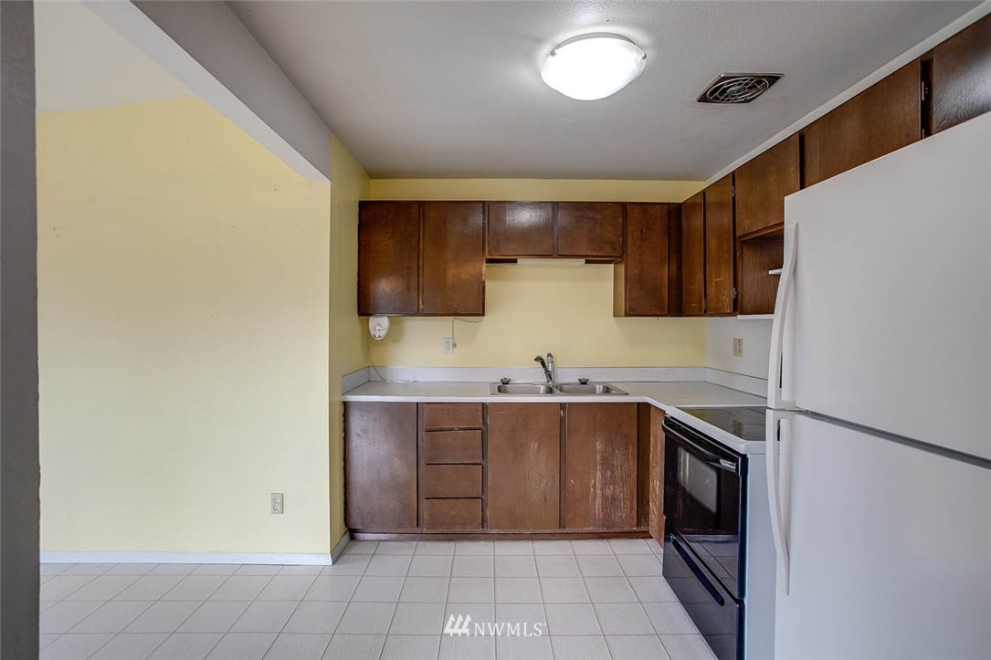4625 Northeast 23rd Street Renton, WA 98059 - Photo 8 of 24 a kitchen with stainless steel appliances a sink and a refrigerator