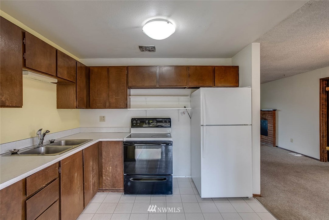 4625 Northeast 23rd Street Renton, WA 98059 - Photo 10 of 24 a kitchen with a sink a refrigerator and cabinets