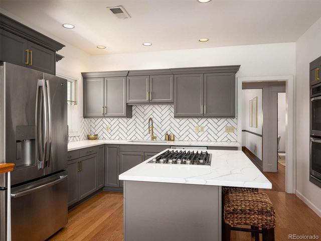 a kitchen with a sink a refrigerator and a stove top oven