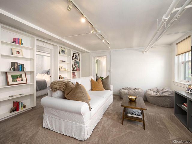 a living room with furniture cabinets and a window
