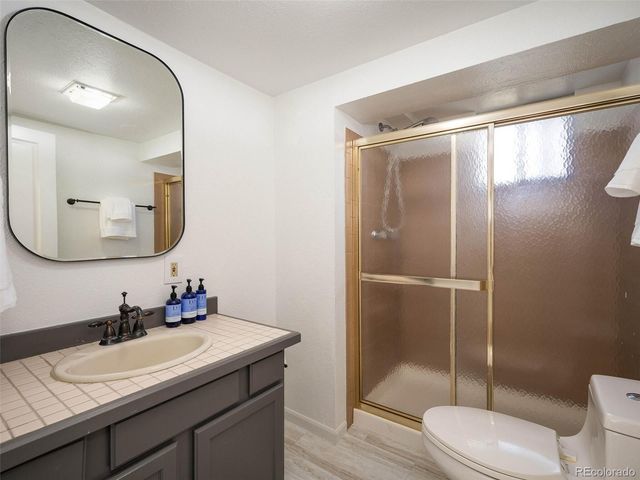 a bathroom with a granite countertop sink toilet a mirror and shower