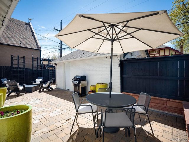 a view of a patio with table and chairs under an umbrella