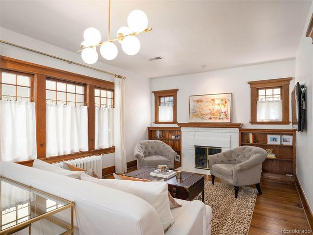 a living room with furniture fireplace and a large window