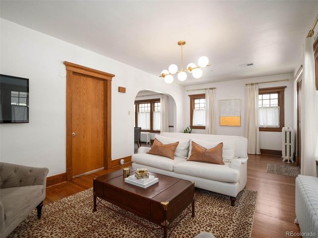a living room with furniture a rug and a chandelier