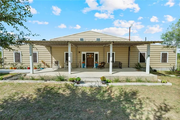 a view of a house with backyard and sitting area