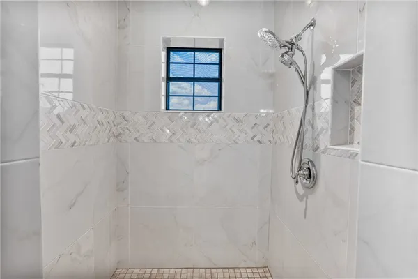 a bedroom with a bed and a large window