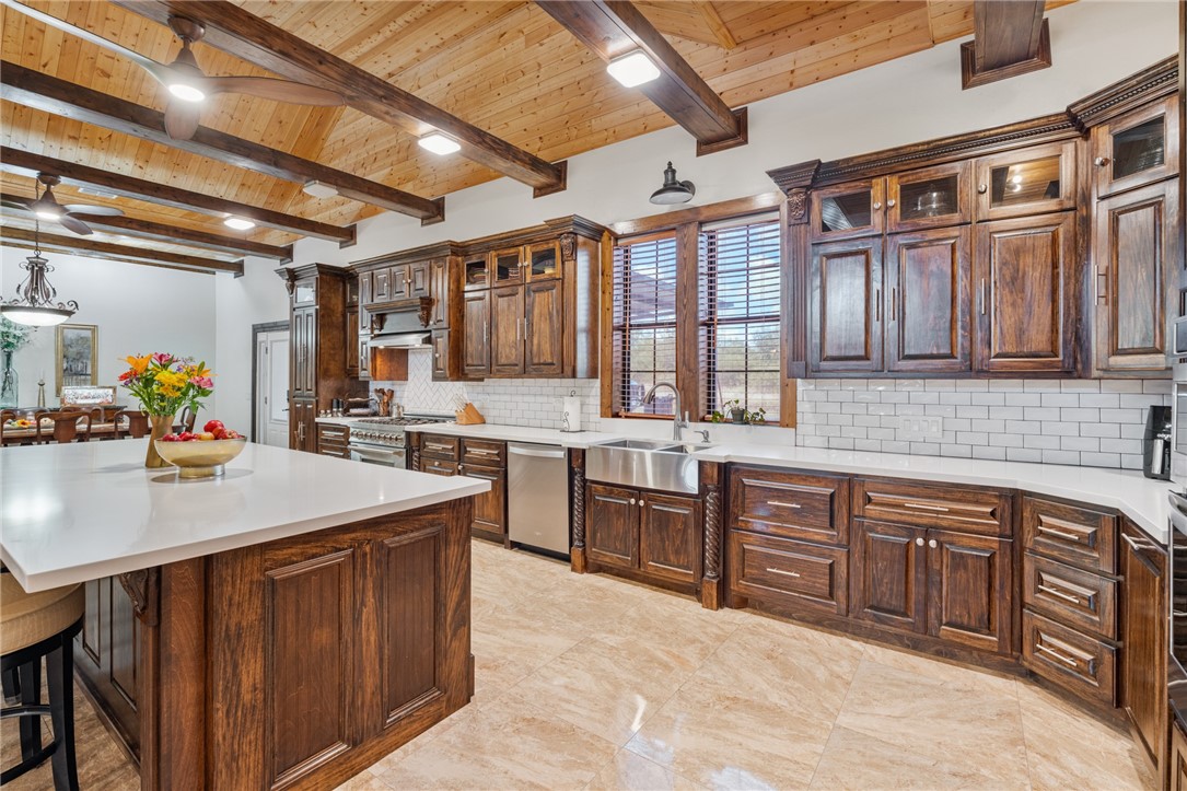 1058 South Smith Street Hebbronville, TX 78361 - Photo 32 of 40 a kitchen with a stove a sink dishwasher and a refrigerator with wooden cabinets