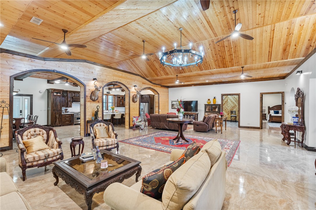 1058 South Smith Street Hebbronville, TX 78361 - Photo 33 of 40 a living room with furniture a chandelier and a dining table with wooden floor