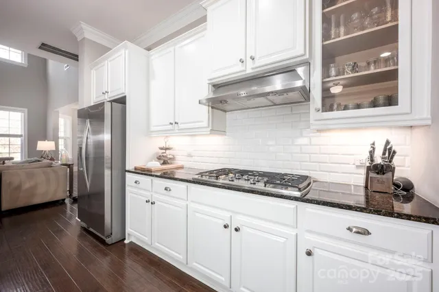 a kitchen with stainless steel appliances granite countertop a refrigerator and a stove