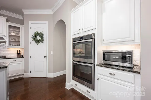a kitchen with granite countertop a stove and a microwave