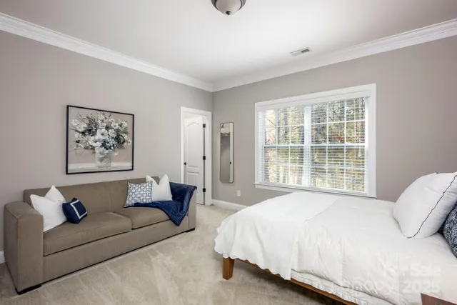 a spacious bedroom with a bed a couch and a window