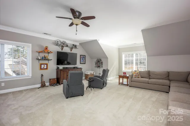 a living room with furniture a flat screen tv and a window