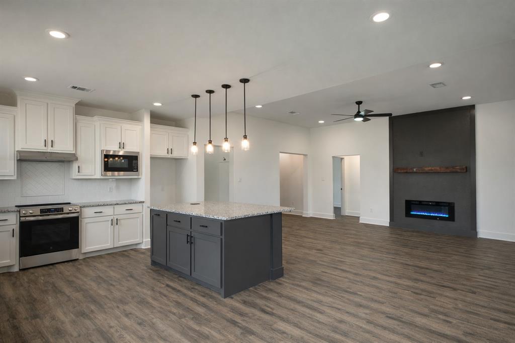 71 Arkansas Road Sadler, TX 76264 - Photo 11 of 35 a large kitchen with stainless steel appliances granite countertop a stove and a wooden floors