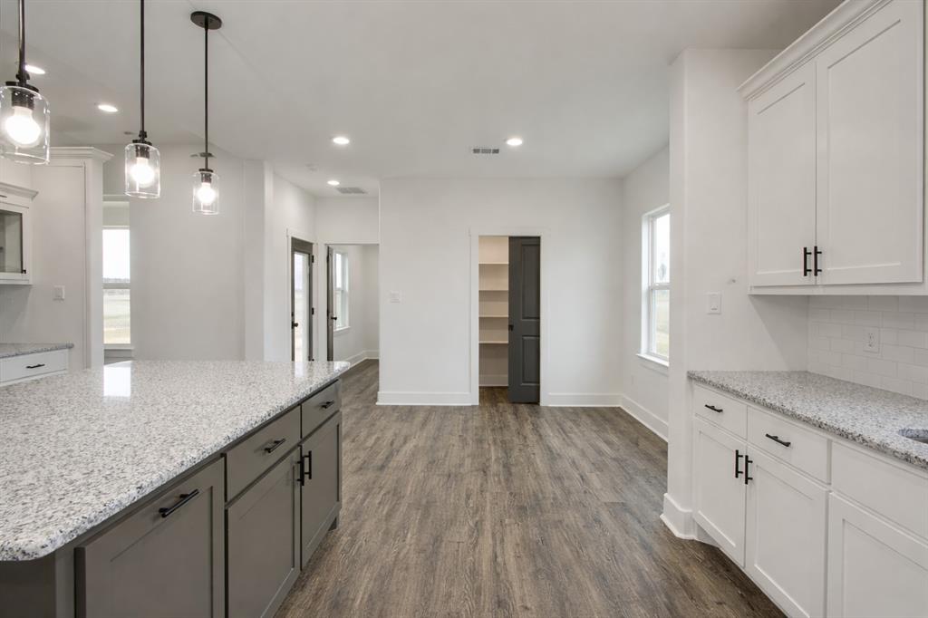 71 Arkansas Road Sadler, TX 76264 - Photo 12 of 35 a kitchen with stainless steel appliances granite countertop a sink a refrigerator and a granite counter tops