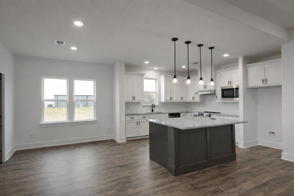 71 Arkansas Road Sadler, TX 76264 - Photo 14 of 35 a kitchen with kitchen island a sink stove and wooden floor