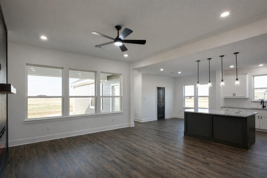 71 Arkansas Road Sadler, TX 76264 - Photo 15 of 35 a view of a kitchen and an empty room with wooden floor and a window