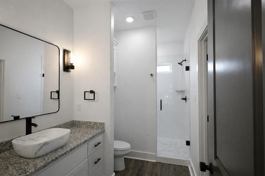 71 Arkansas Road Sadler, TX 76264 - Photo 21 of 35 a bathroom with a granite countertop sink toilet and shower