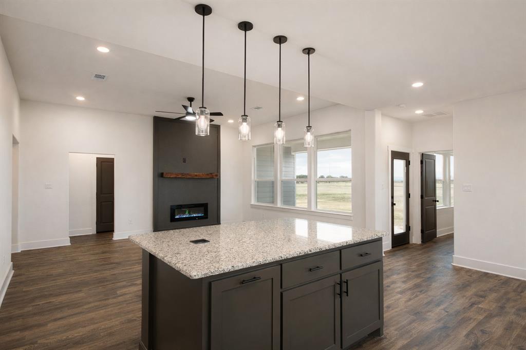 71 Arkansas Road Sadler, TX 76264 - Photo 6 of 35 a kitchen with stainless steel appliances kitchen island granite countertop a refrigerator a oven and a wooden floors