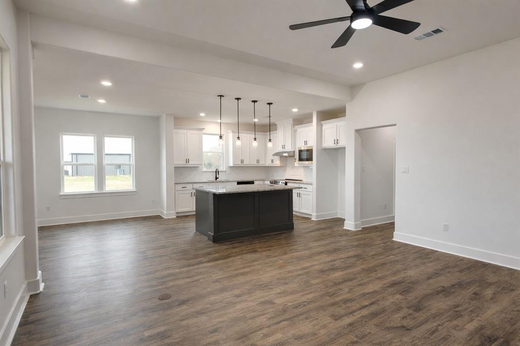 71 Arkansas Road Sadler, TX 76264 - Photo 7 of 35 a large kitchen with cabinets and wooden floor