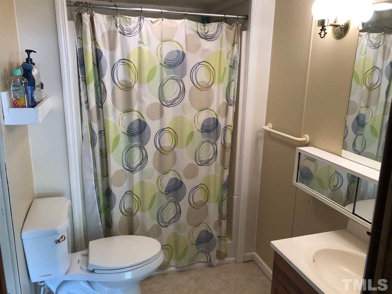 9546-9548 George Ruff Road Bullock, NC 27507 - Photo 11 of 25 a white toilet sitting next to a shower curtain