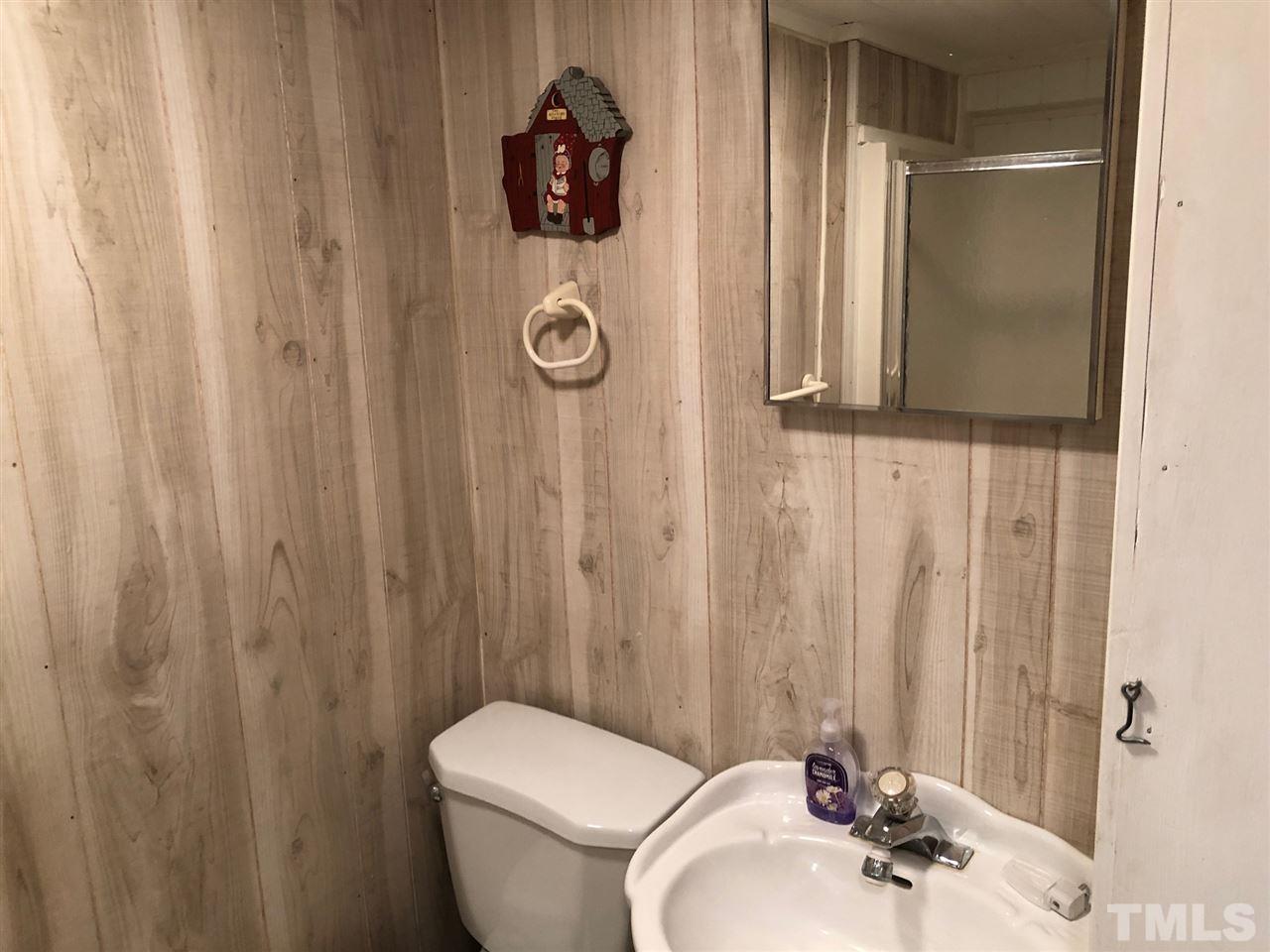9546-9548 George Ruff Road Bullock, NC 27507 - Photo 14 of 25 a bathroom with a sink and mirror with toilet