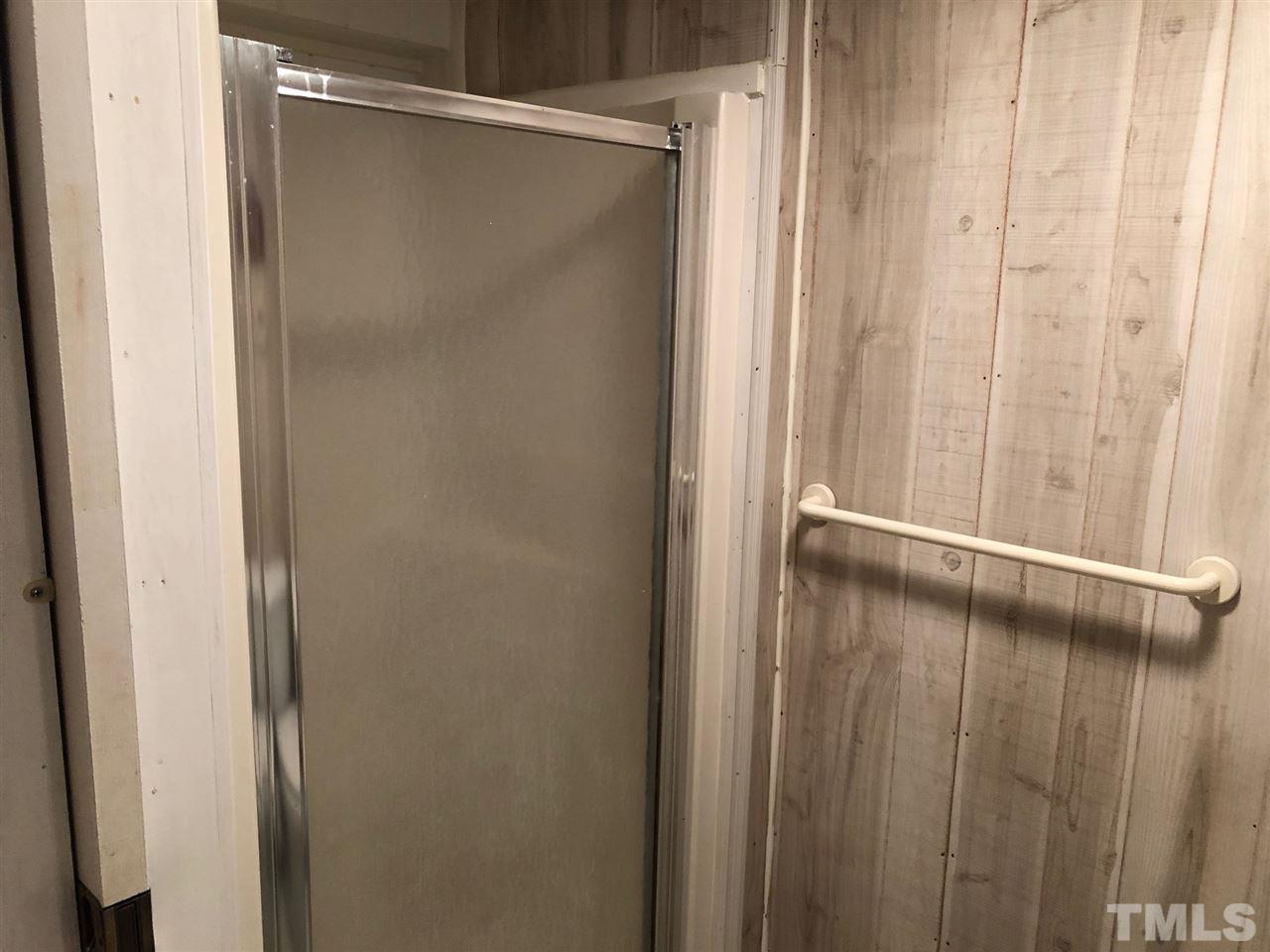 9546-9548 George Ruff Road Bullock, NC 27507 - Photo 15 of 25 a bathroom with a glass shower door